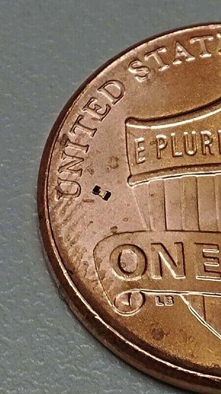 The microrobot can be seen just to the right of the “U” in United States on this U.S. penny. (Purdue University image/Georges Adam)